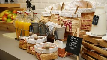 A variety of food items and beverages displayed on a counter, including jars, paper bags, and a chalkboard sign.