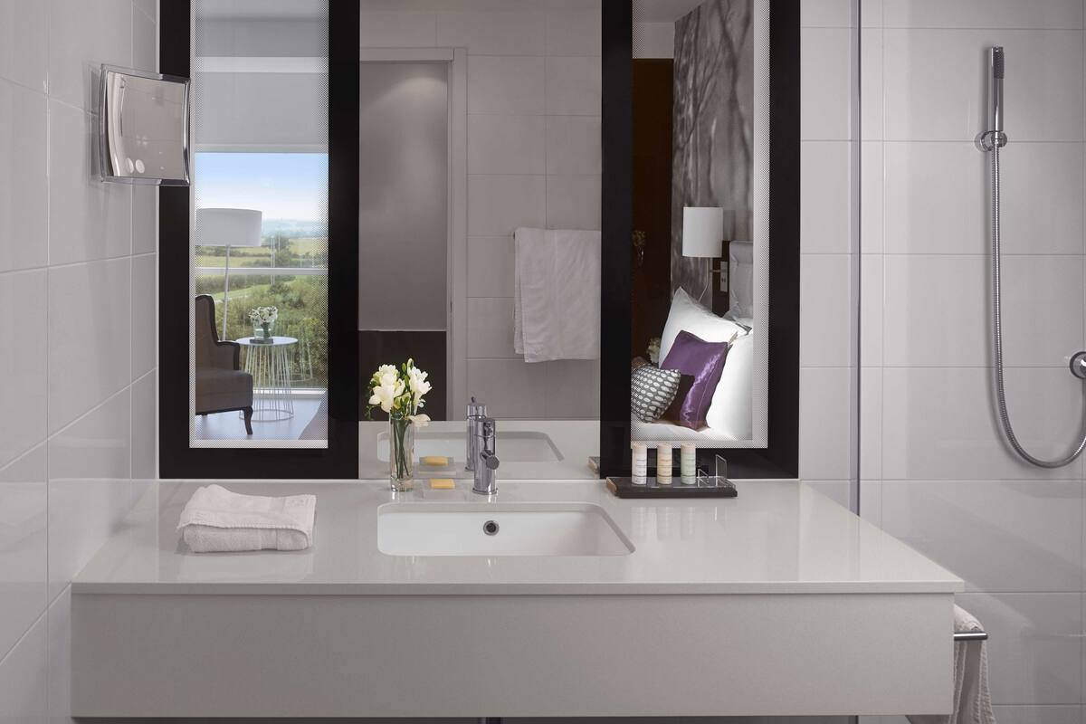superior room (runway view) | bathroom | free toiletries, hair dryer, slippers, towels