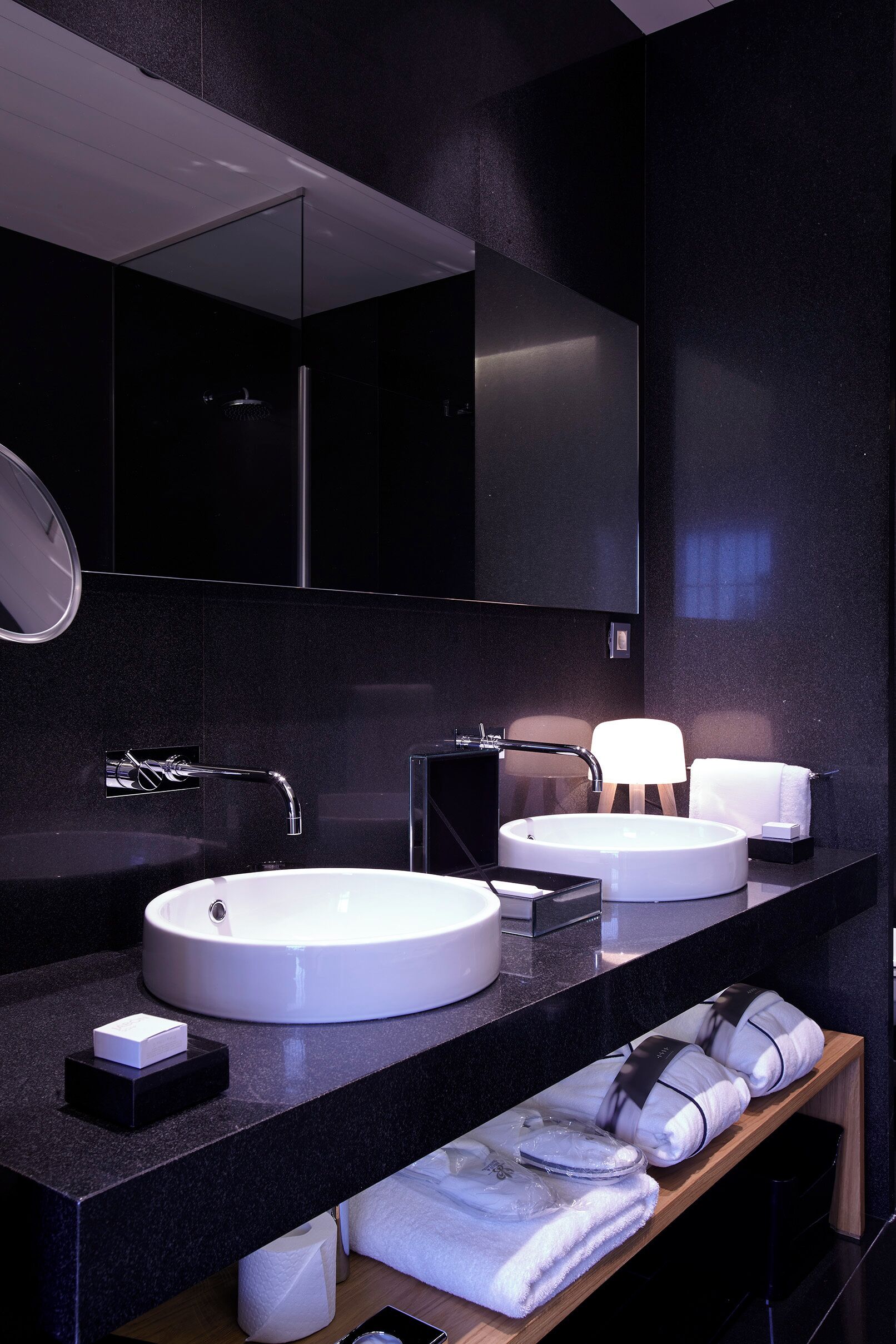 Ein modernes Badezimmer mit zwei Waschbecken, einem Spiegel und einem Handtuchhalter.