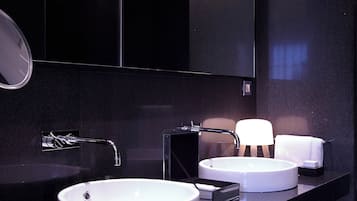 Ein modernes Badezimmer mit zwei Waschbecken, einem Spiegel und einem Handtuchhalter.