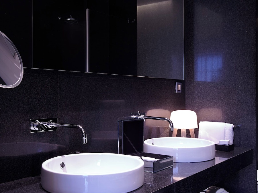 Ein modernes Badezimmer mit zwei Waschbecken, einem Spiegel und einem Handtuchhalter.