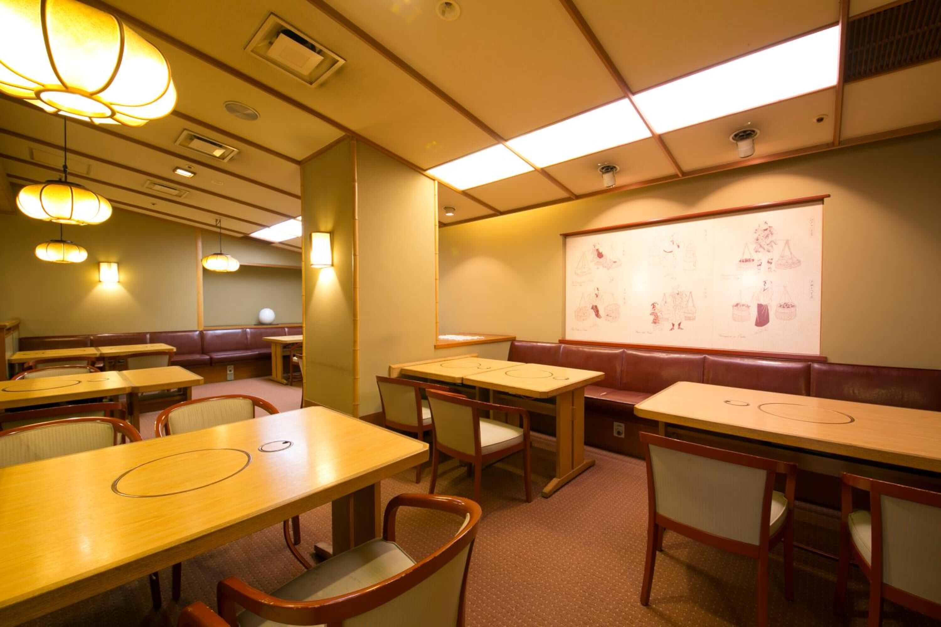 A conference room with tables, chairs, a whiteboard, and a projector screen.