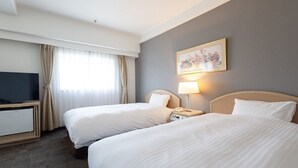 Een hotelkamer met twee bedden, een televisie, een lamp en een schilderij aan de muur.