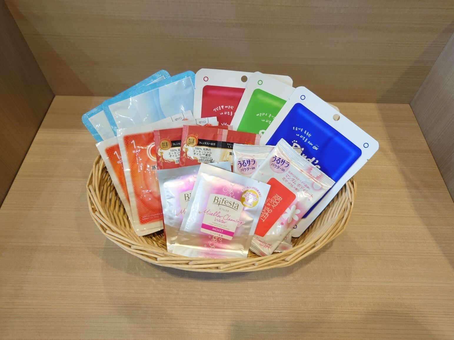 Un panier en osier rempli de divers produits emballés, notamment des produits de soins pour la peau.