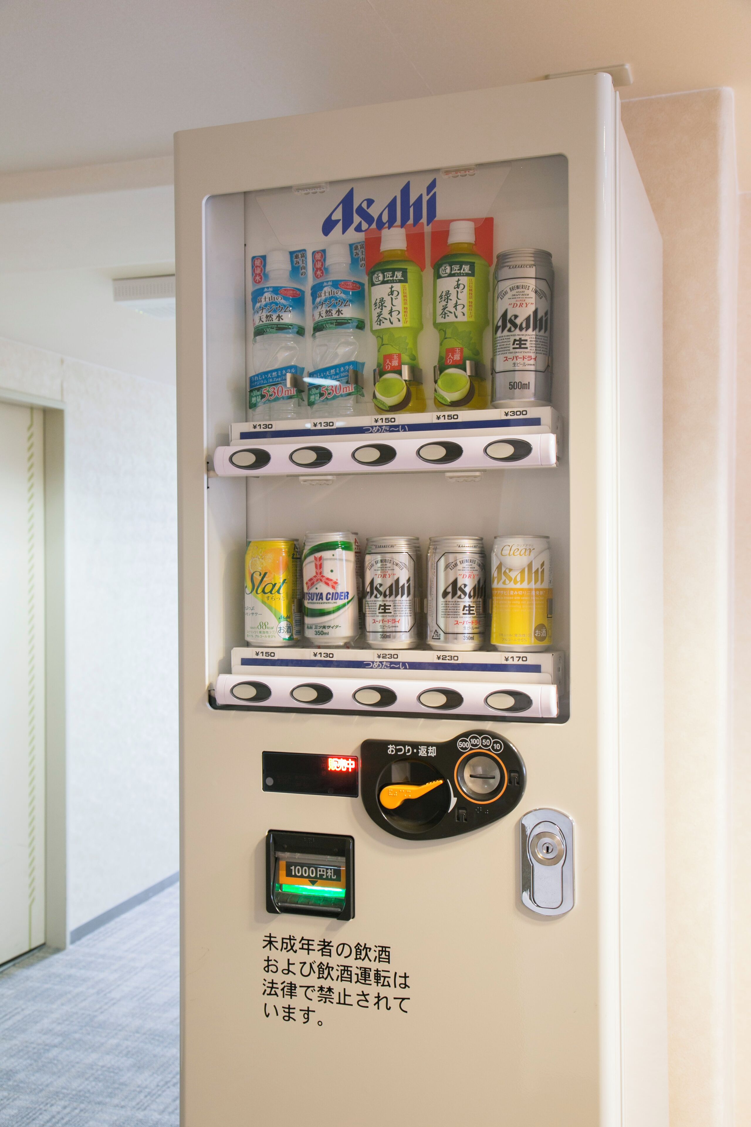 Máquina de vendas com diversas bebidas e um terminal de pagamento.