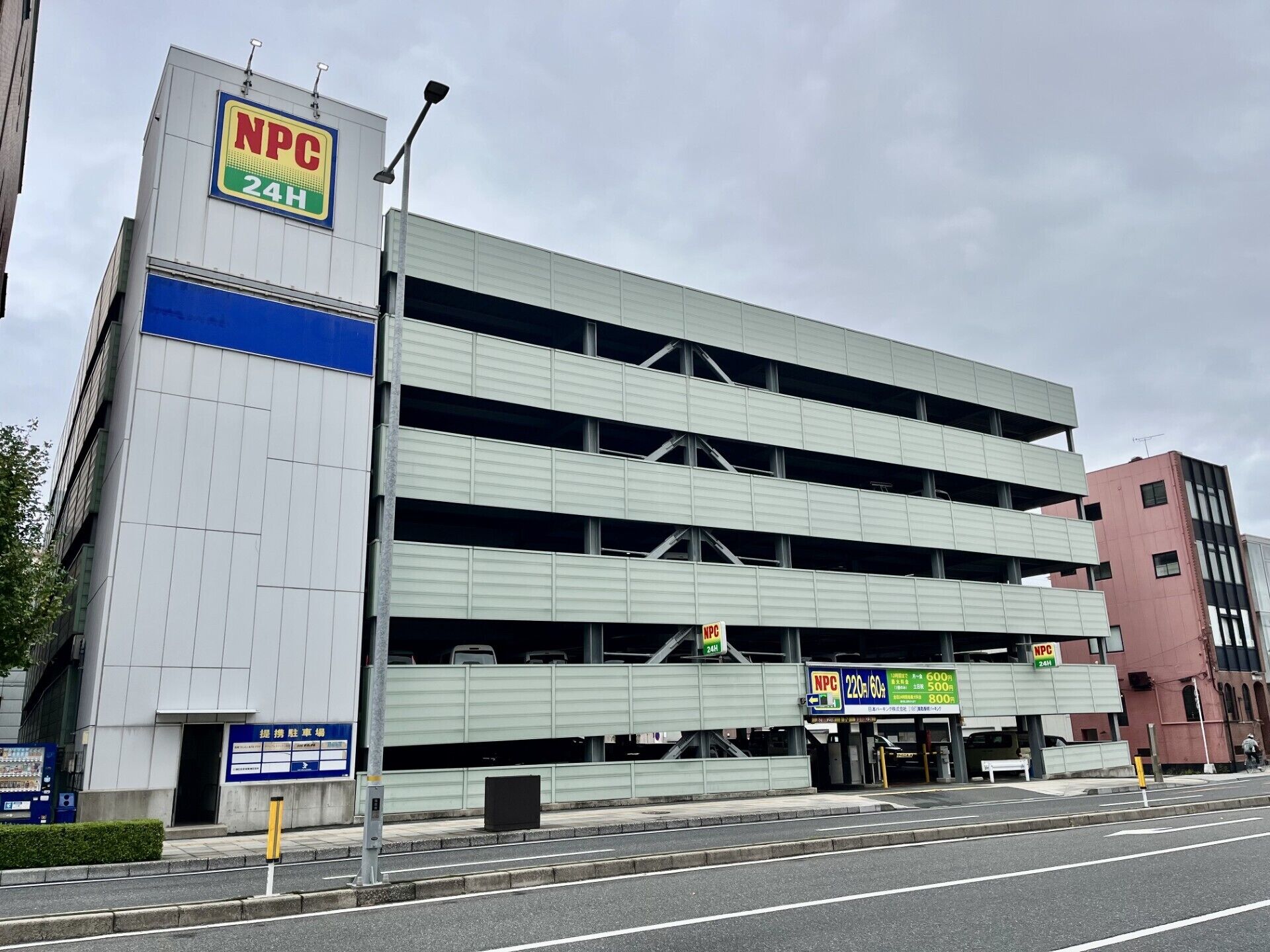 Un parking à étages avec un panneau indiquant qu’il est ouvert 24 heures sur 24.
