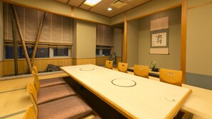 Una habitación japonesa tradicional con esteras de tatami, una mesa baja y sillas de madera.