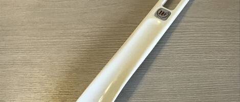 A white object with a handle and a logo on a wooden surface.