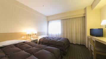 Habitación de hotel con dos camas, un escritorio con televisor y una ventana con cortinas.
