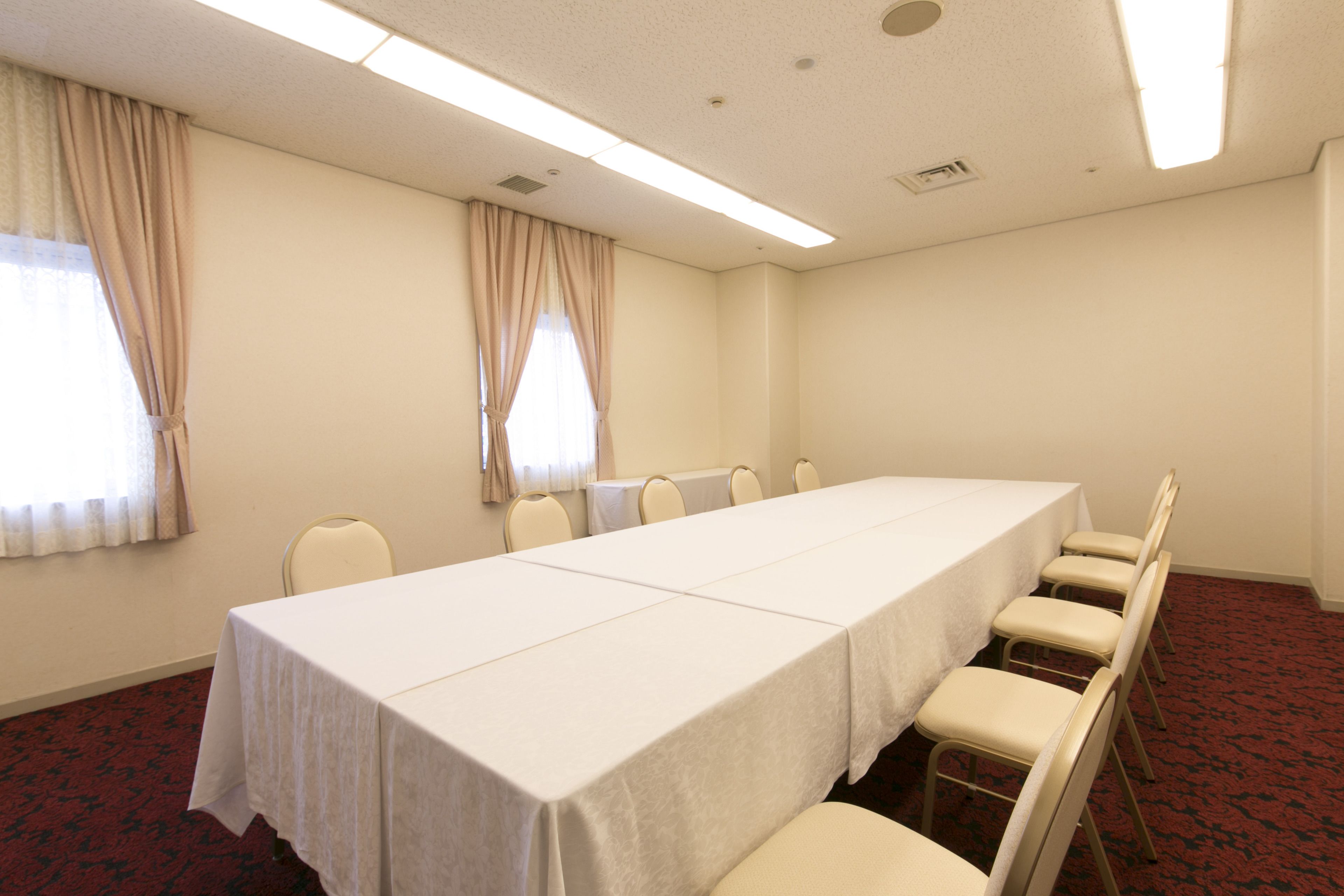 A conference room with a long table and six chairs.