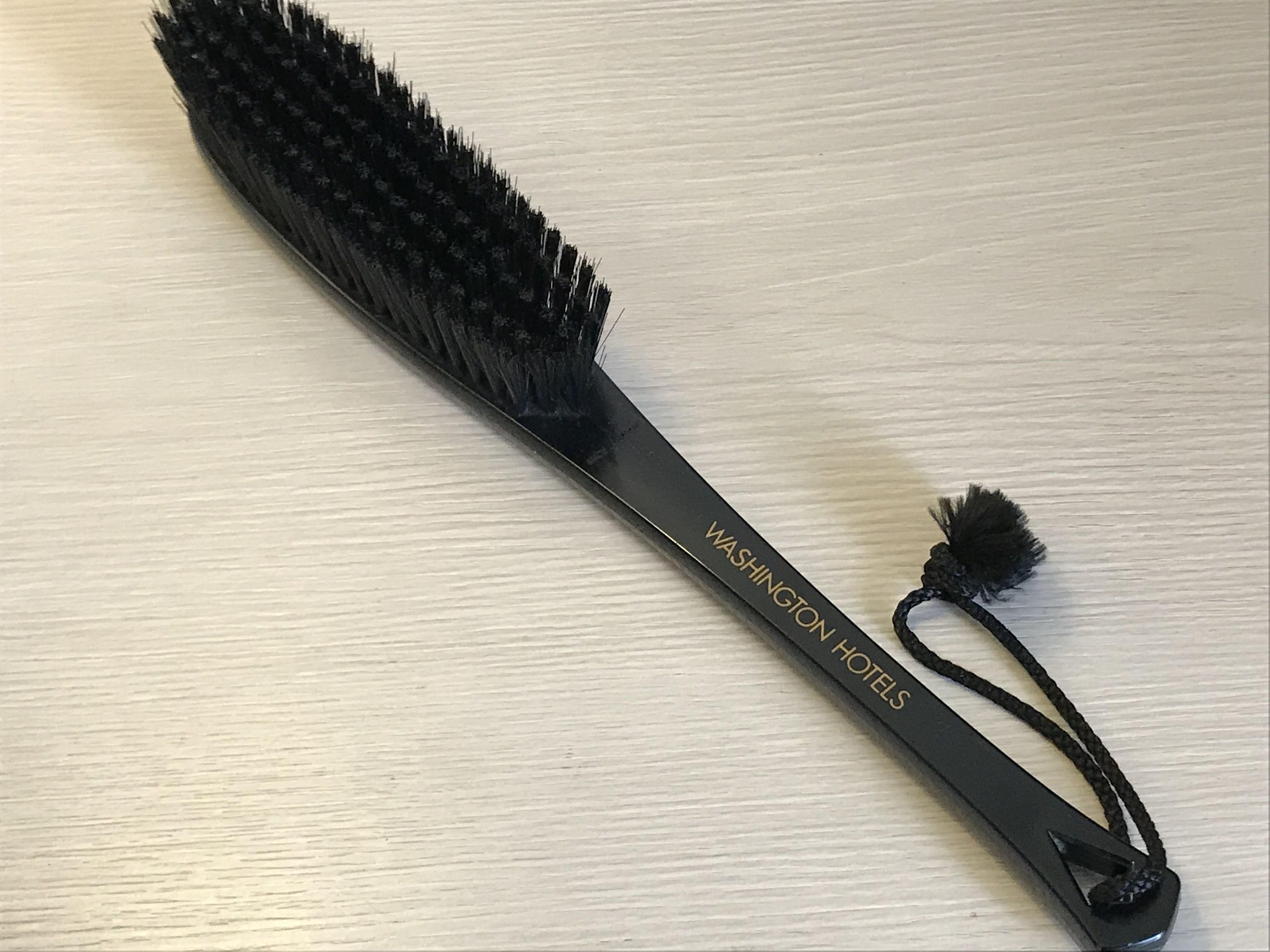 Eine schwarze Haarbürste mit Quaste, beschriftet mit 'Washington Hotels'.