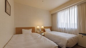 A hotel room with two beds, a nightstand with lamps, a telephone, and a window with curtains. - Shimonoseki Station West Washington Hotel Plaza (Shimonoseki)
