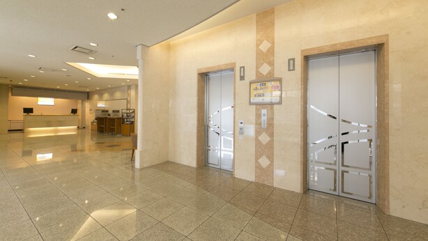A spacious lobby with a reception desk, two elevators, and a clean, tiled floor. - Shimonoseki Station West Washington Hotel Plaza (Shimonoseki)