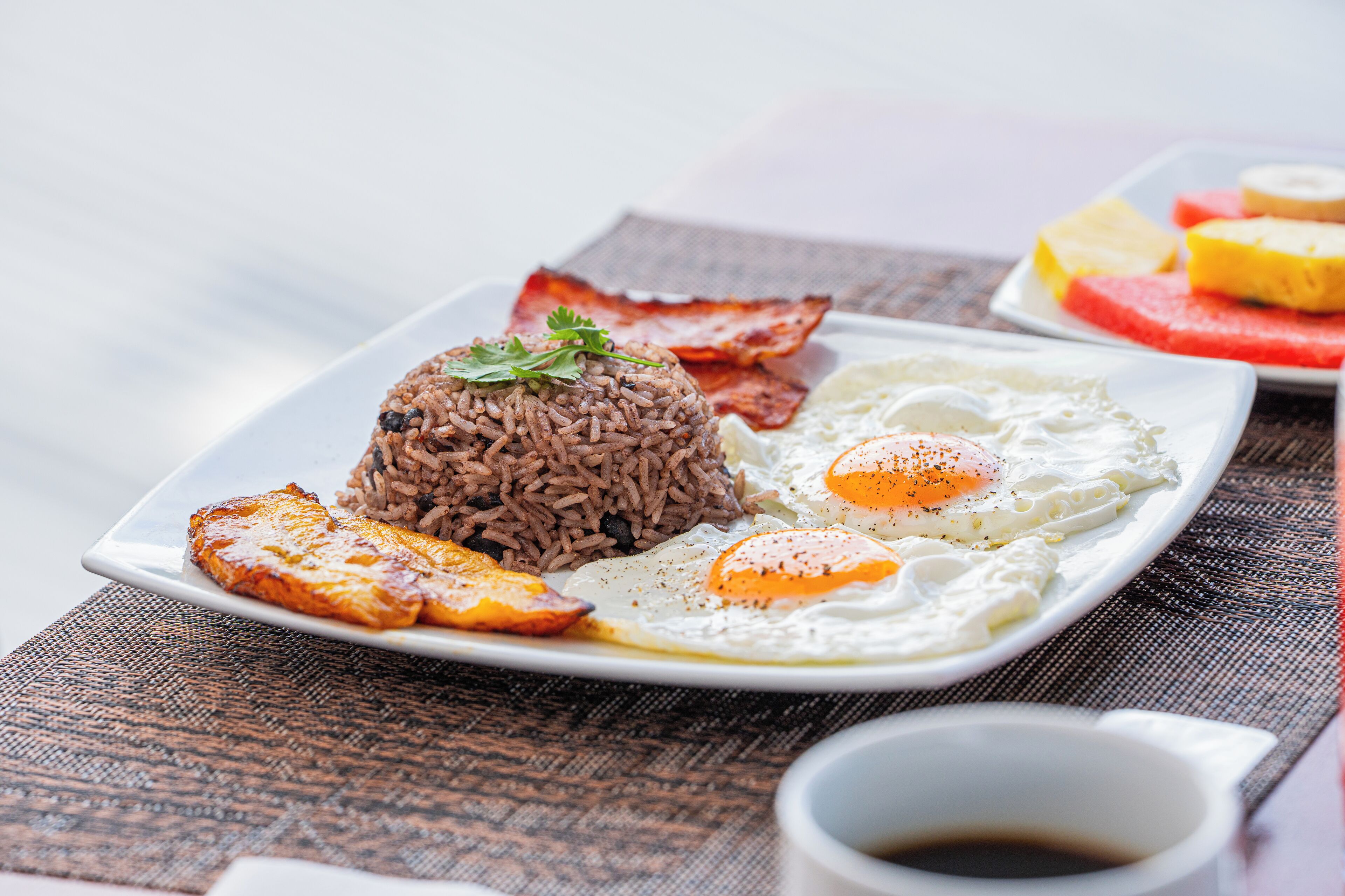 A plate of food with rice, eggs, and bacon.