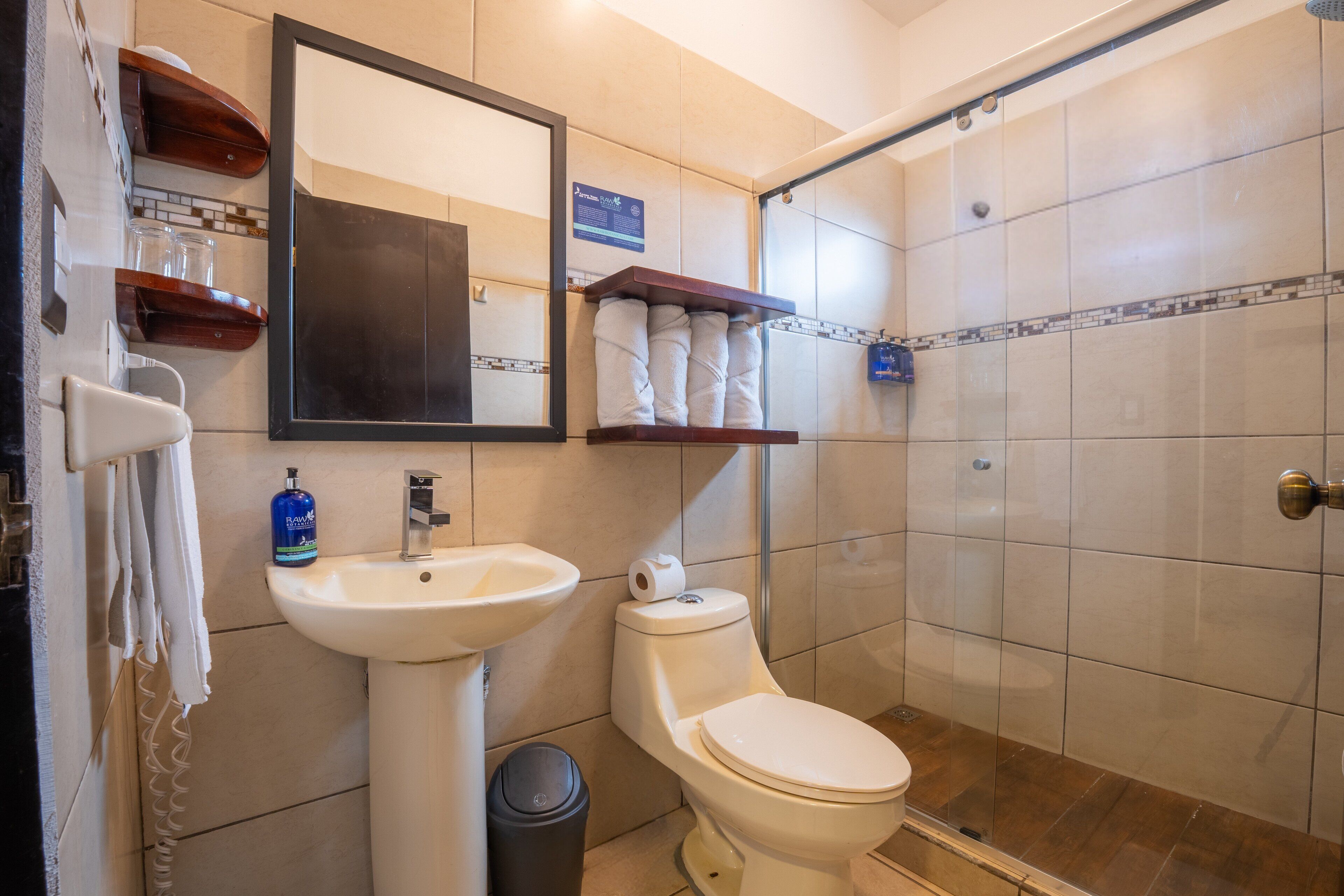 A bathroom with a sink, toilet, and a shower area.