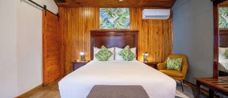 A bedroom with a large bed, wooden ceiling, and a ceiling fan.