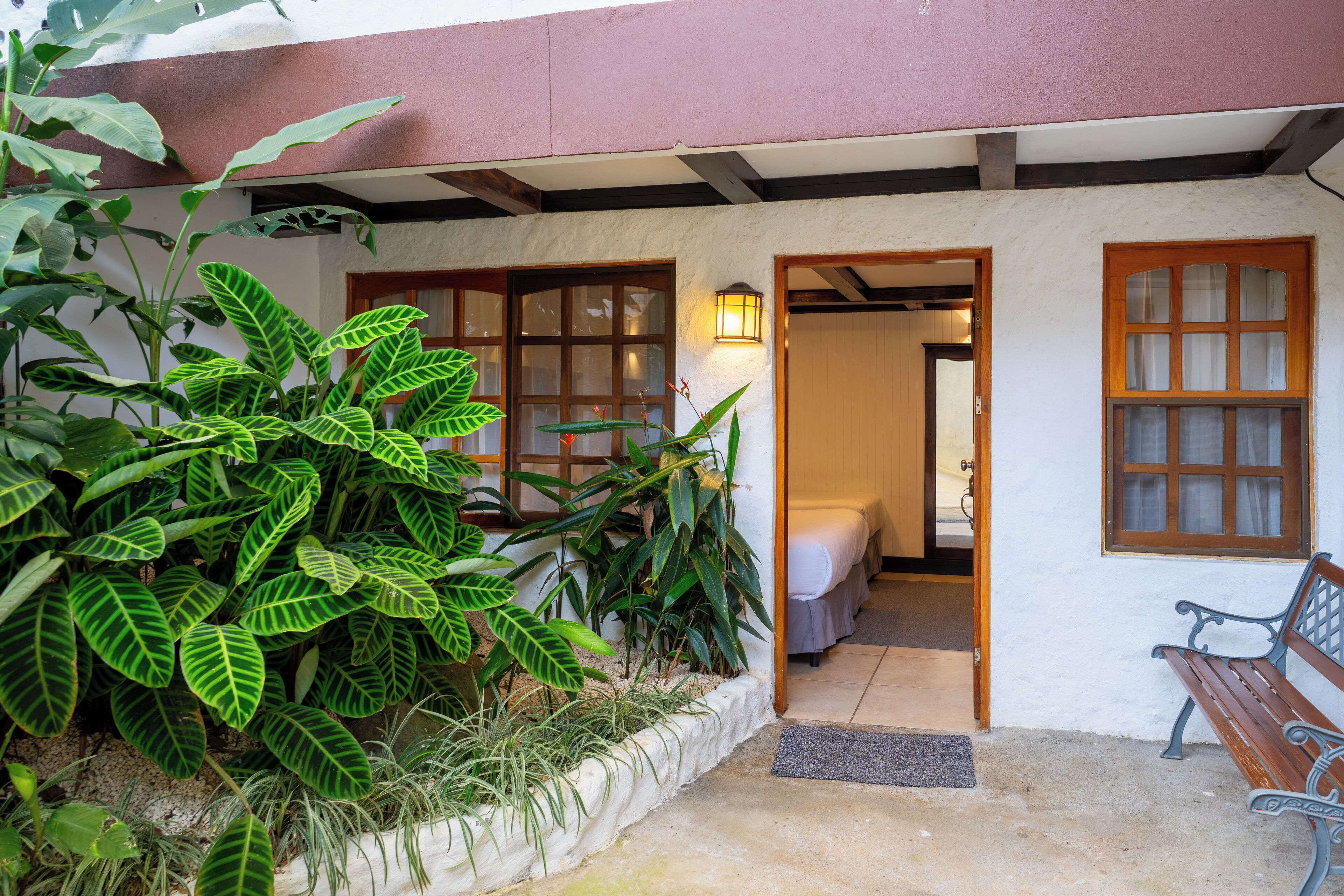 A traditional building with a white exterior, wooden doors, and a bench outside.