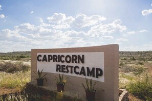 A sign for Capricorn Restcamp with three potted plants in front. - Capricorn Restcamp (Rietoog)