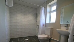 Ein Badezimmer mit Dusche, Toilette und Waschbecken.