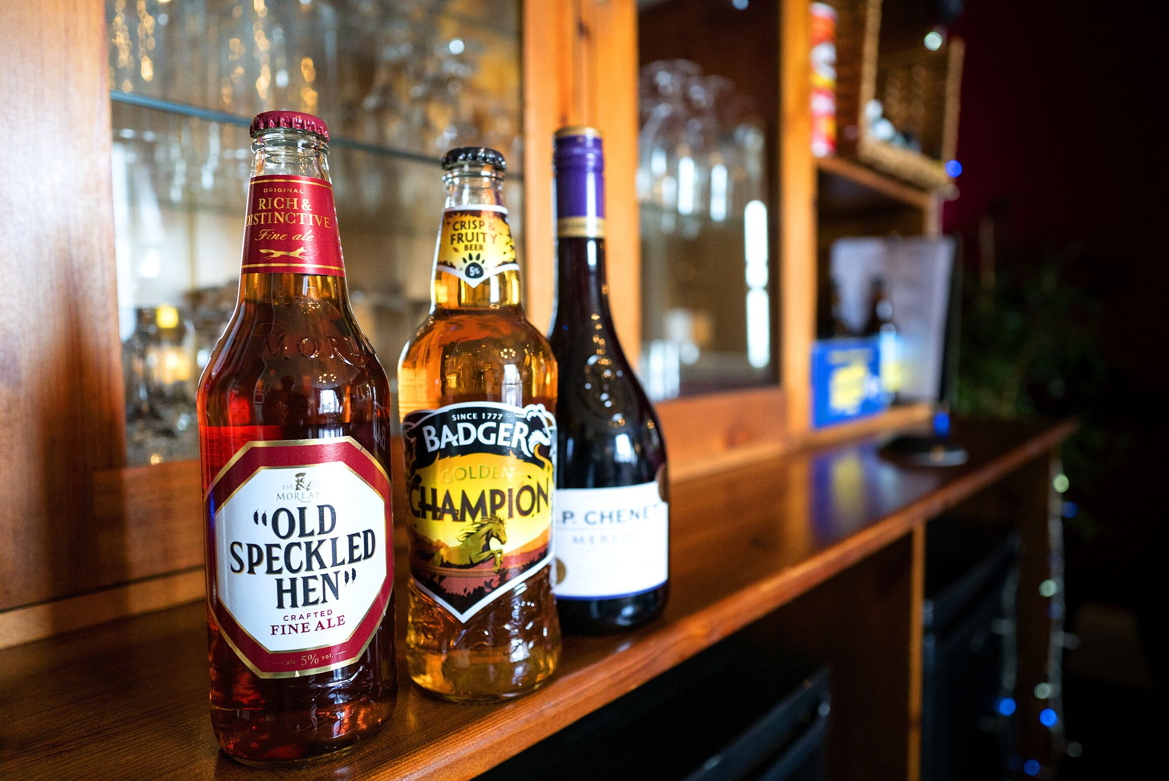 Three bottles of beer on a bar counter.
