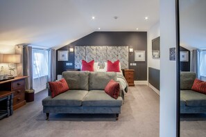 A bedroom with a bed, a sofa, a desk, and a large mirror. - The Helaina (Scarborough)