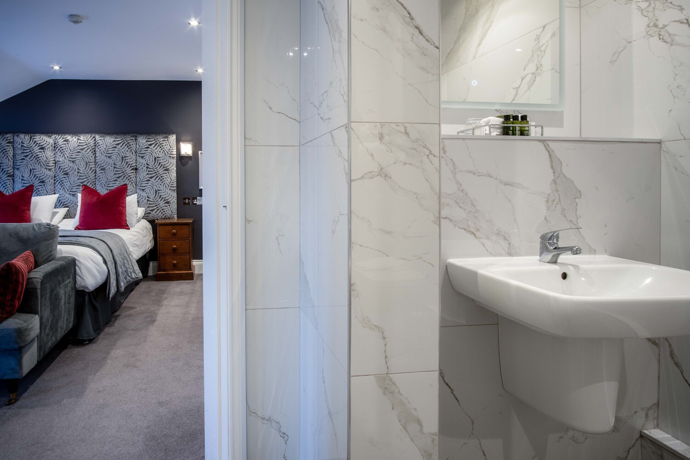 A modern bedroom with a large bed, a bedside table, and a nightstand.