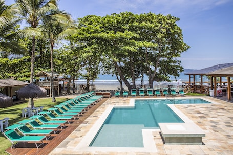 Una piscina al aire libre, sombrillas, sillones reclinables de piscina