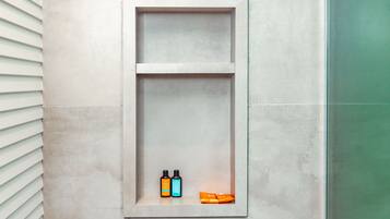 Un bagno con una mensola a muro contenente articoli da toilette.
