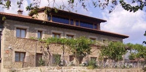 Un bâtiment en pierre doté de nombreuses fenêtres et d’un balcon.