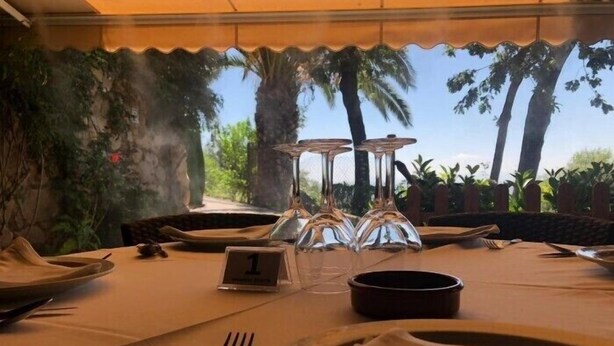 A table set for one with a number 1 placemat, a fork, a knife, a glass, and a bowl. - Hotel Casa Rural Ropino (Candeleda)