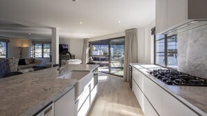 Uma cozinha moderna com ilha central, fogão embutido e uma grande janela com vista para o exterior.