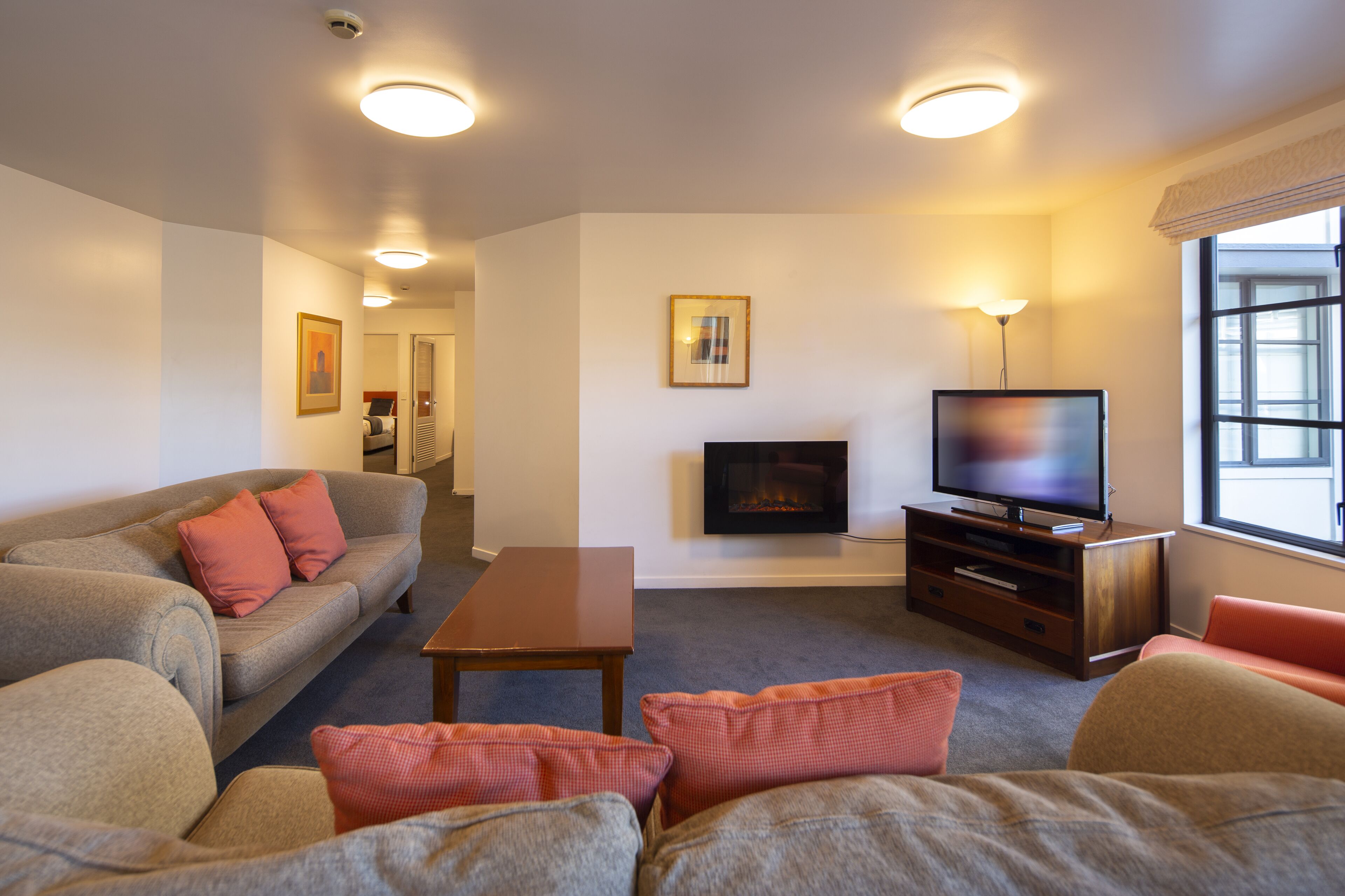 Una sala de estar con un sofá, una mesa de centro, un televisor y una chimenea.