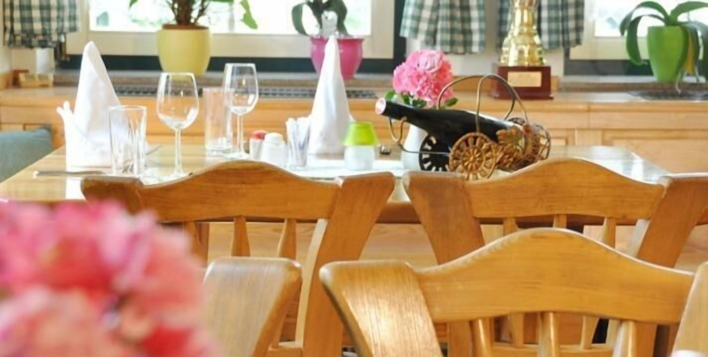 Une table à manger, avec des chaises, une bouteille et un objet décoratif.