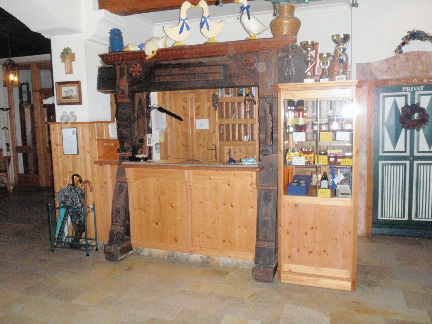 Eine Bar mit Holztresen, Regalen voller Flaschen.