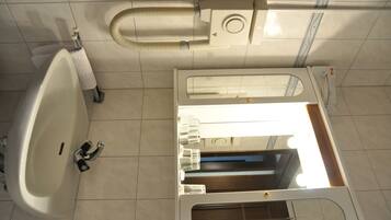 Une salle de bain équipée d’une baignoire, de toilettes et d’un meuble-lavabo avec un miroir et un évier.