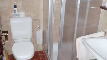 Un baño con inodoro, ducha y lavabo.