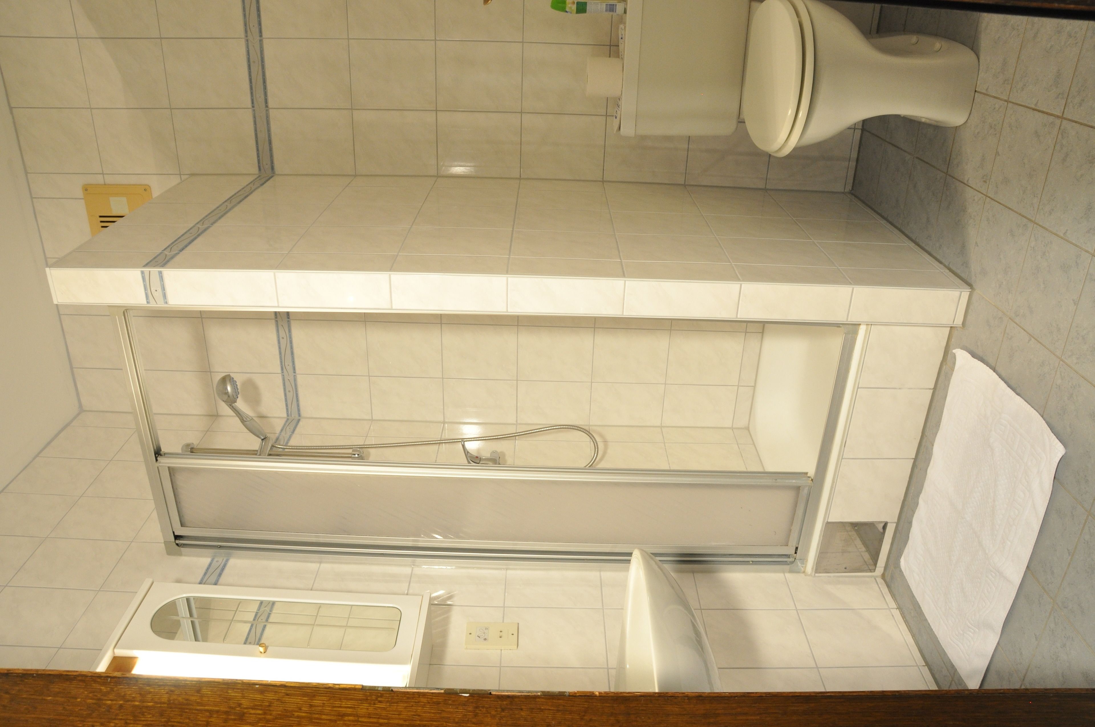 A bathroom with a toilet, sink, and shower area.