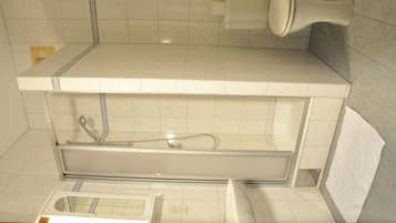A bathroom with a toilet, sink, and shower area.