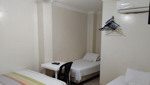 A small, clean room with two beds, a desk, and a chair. - Jeshua Inn Guayaquil (Guayaquil)