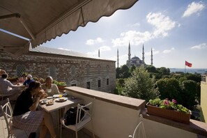 A terrace with a view of a mosque and a flag. - Hotel Turkoman (Istanbul)