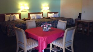 A hotel room with two beds, a dining table with chairs, and lamps on the wall. - Super 7 Inn Siloam Springs (Siloam Springs)