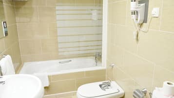 A bathroom with a bathtub, toilet, and sink.