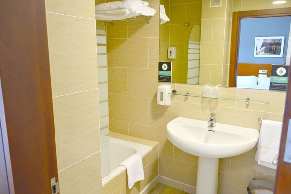 A bathroom with a bathtub, a sink, and a mirror.