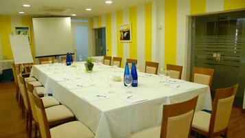 A conference room with a long table, chairs, and a whiteboard.