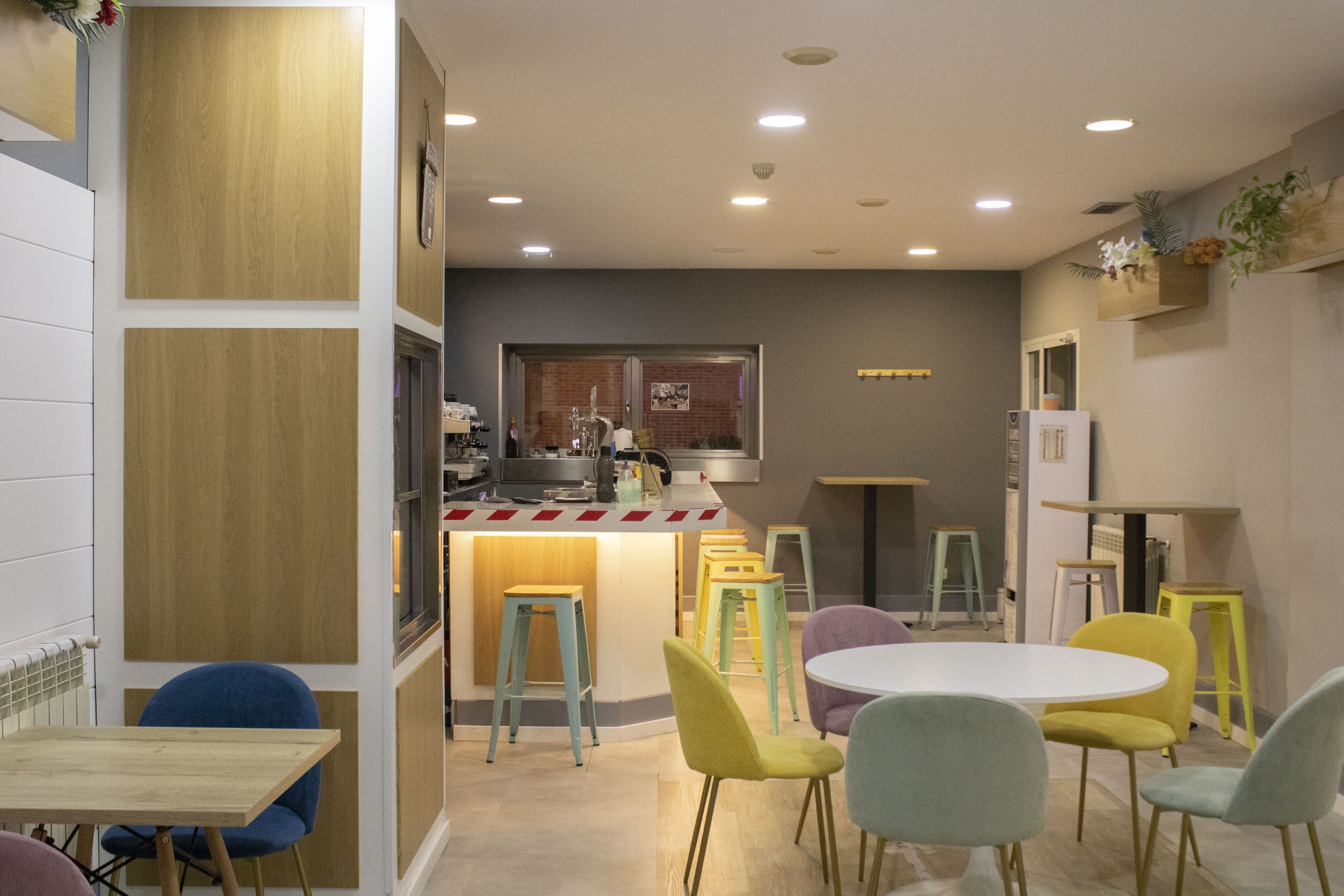 A modern dining area with a central island, multiple stools, and a variety of chairs.