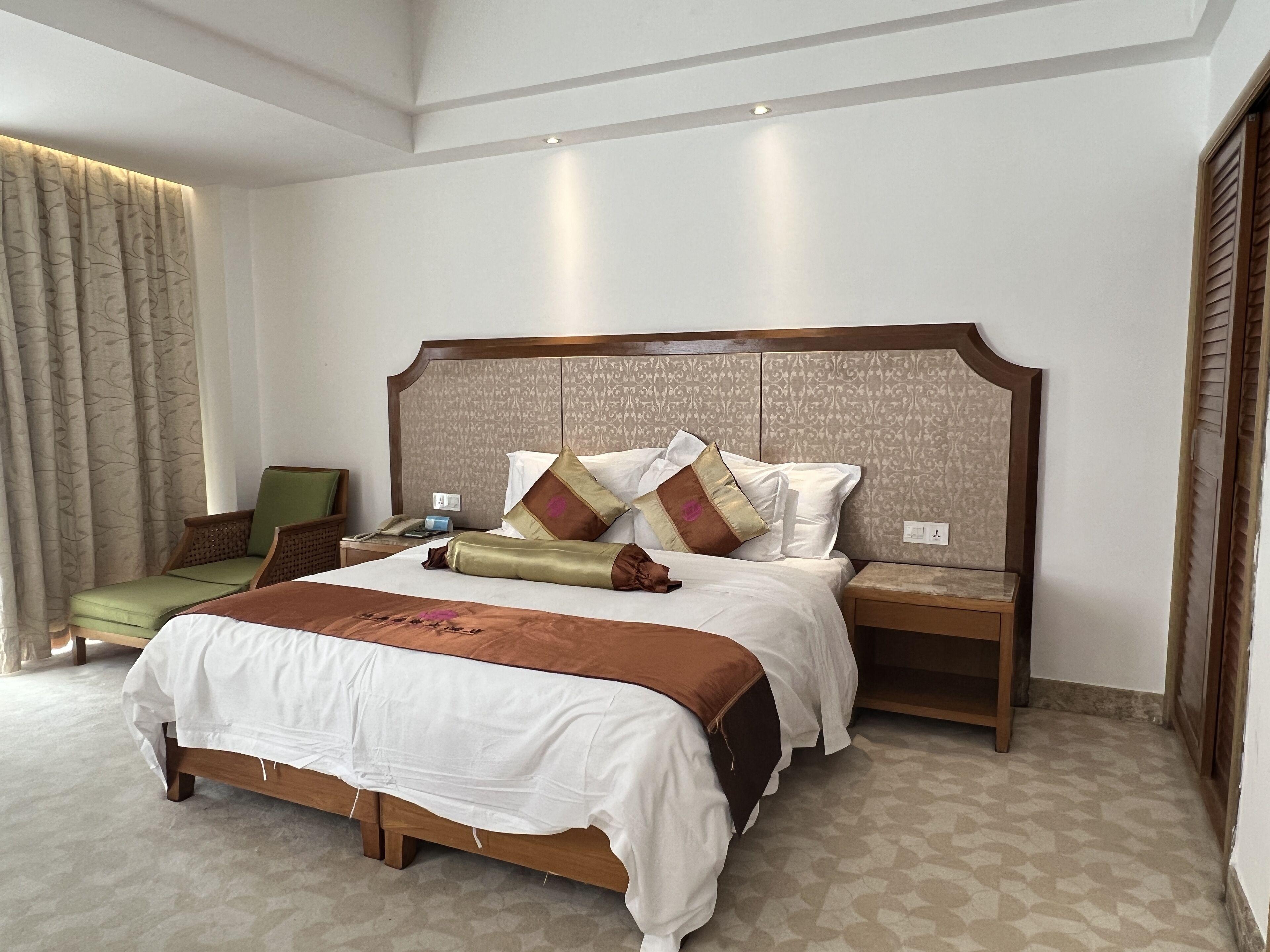 Un dormitorio espacioso con una cama grande, cabecero de madera y una mesita de noche.