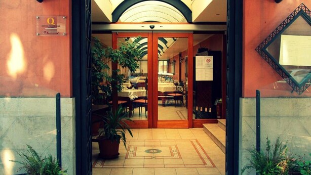 The entrance to La Lumìere Ristorante with a covered entrance, potted plants, and a tiled floor. - Hotel de Paris (Terni)