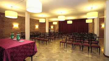 A conference room with a long table, multiple chairs, and pendant lighting.