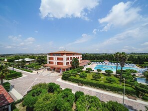 A hotel with a swimming pool, a landscaped garden, and a view of the countryside.