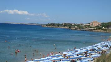 On the beach, white sand, free beach shuttle, beach umbrellas